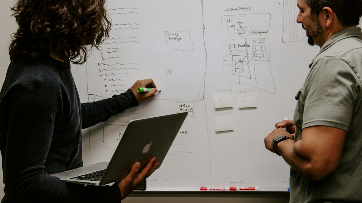 Two people sketching a system on paper